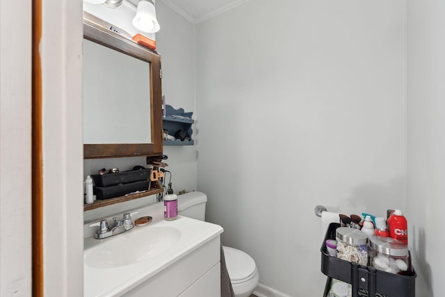 bathroom featuring crown molding, vanity, and toilet