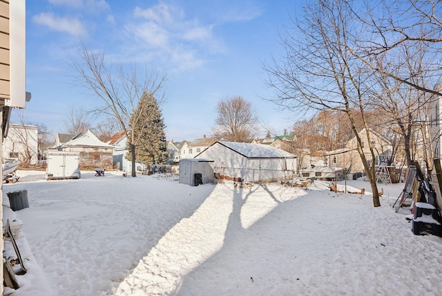 yard covered in snow featuring a shed