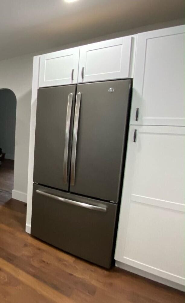 interior details with white cabinetry, dark hardwood / wood-style flooring, and stainless steel fridge