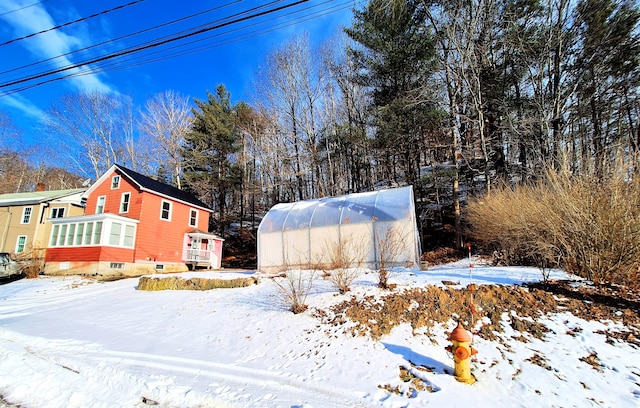 yard layered in snow featuring an outbuilding