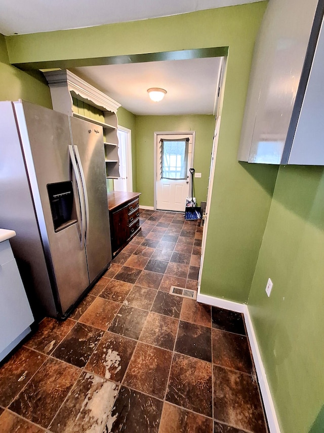 kitchen with dark brown cabinetry and stainless steel fridge with ice dispenser