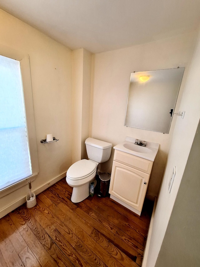 bathroom with hardwood / wood-style flooring, vanity, and toilet