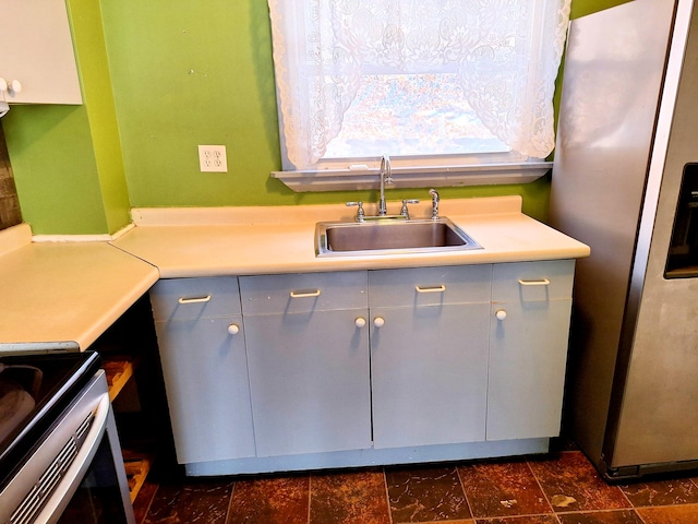 kitchen with sink, electric range oven, and stainless steel refrigerator with ice dispenser