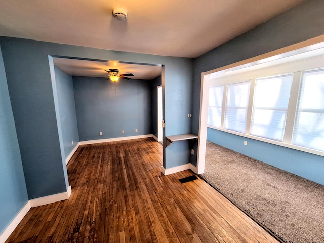 unfurnished living room with wood-type flooring and ceiling fan