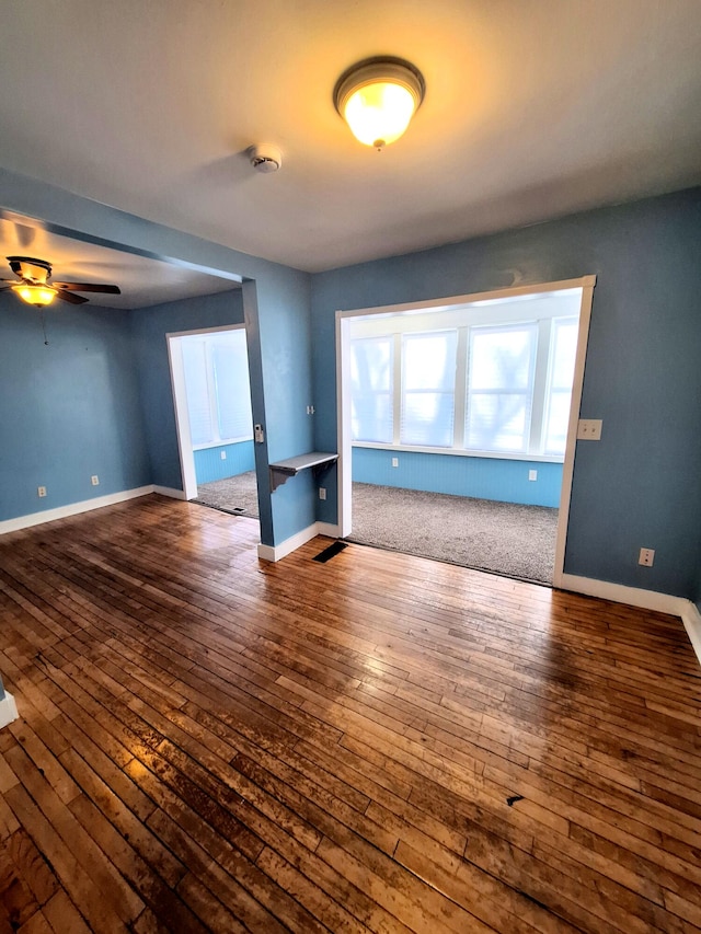 unfurnished living room with ceiling fan and hardwood / wood-style floors