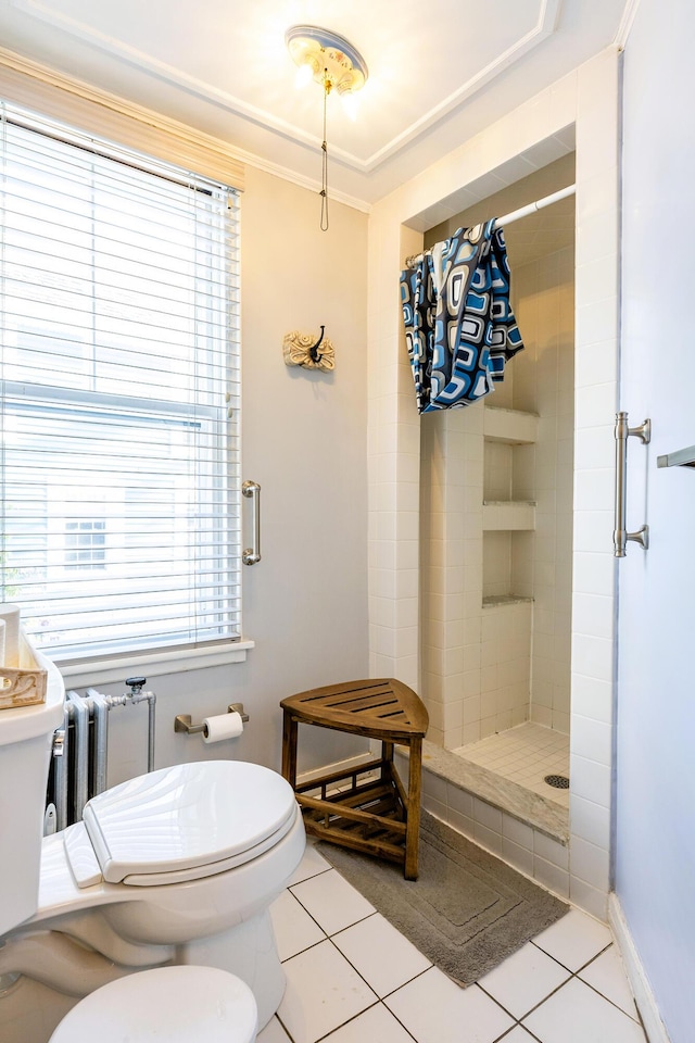 bathroom featuring tile patterned floors, radiator heating unit, toilet, and a tile shower