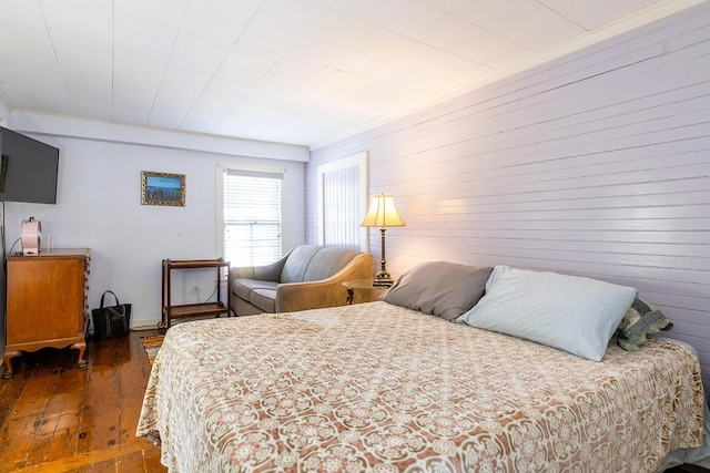 bedroom with dark hardwood / wood-style flooring and crown molding