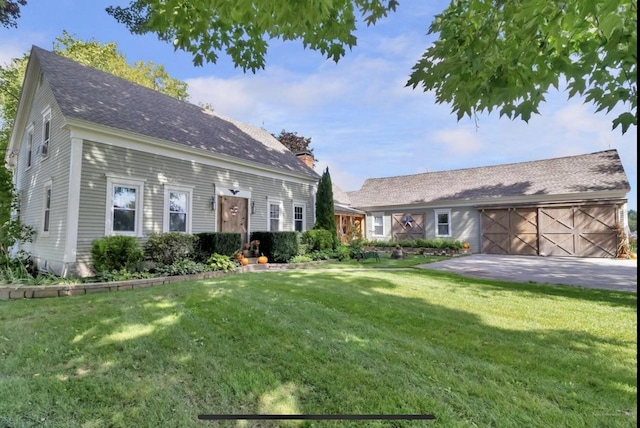 view of front of property featuring roof with shingles, an attached garage, driveway, and a front lawn