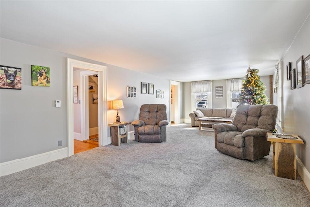 living area featuring light colored carpet and baseboards