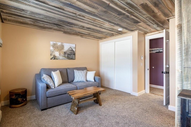 living area featuring carpet, wood ceiling, and baseboards