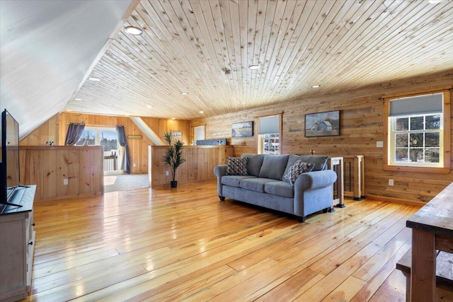 living room with wood walls, light wood-type flooring, and wood ceiling