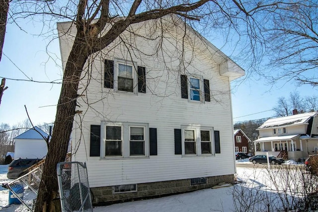 view of snow covered back of property