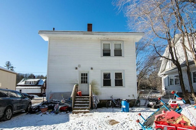 view of snow covered back of property