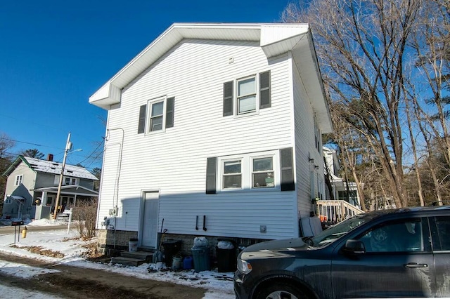 view of snow covered rear of property