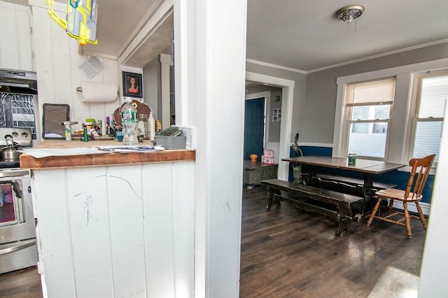 kitchen with crown molding, dark wood-type flooring, and stainless steel range with electric cooktop