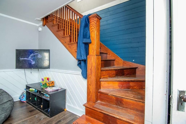 stairway with crown molding and hardwood / wood-style floors