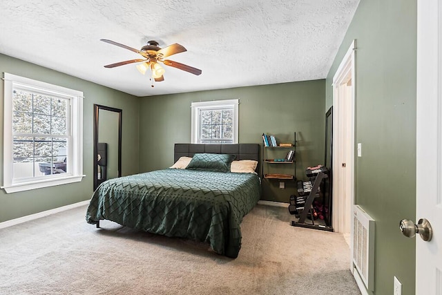 carpeted bedroom featuring ceiling fan and a textured ceiling