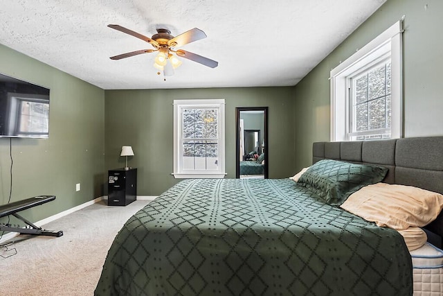 bedroom with multiple windows, carpet, and a textured ceiling