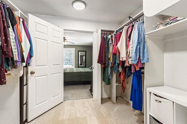 spacious closet featuring light colored carpet and ceiling fan