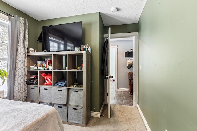 bedroom featuring light colored carpet and a textured ceiling