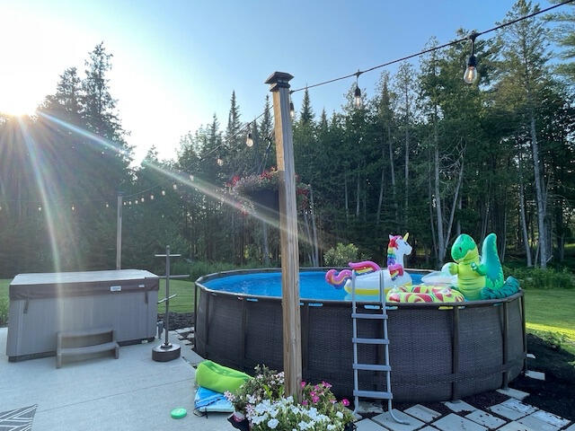 view of patio / terrace with a swimming pool with hot tub