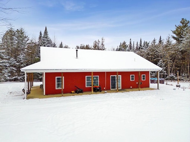 view of snow covered back of property