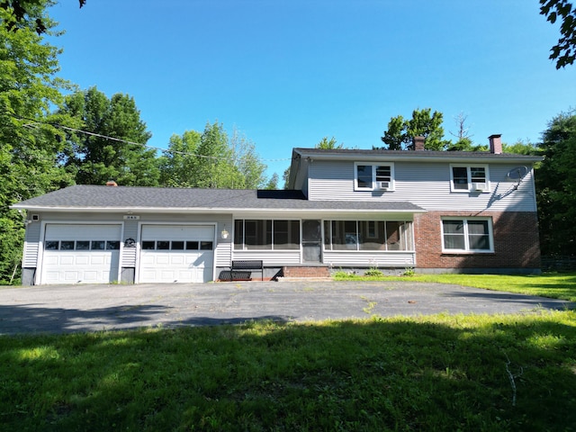 view of front of property with a garage and a front lawn