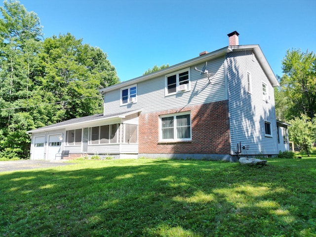 rear view of property featuring a yard and a garage