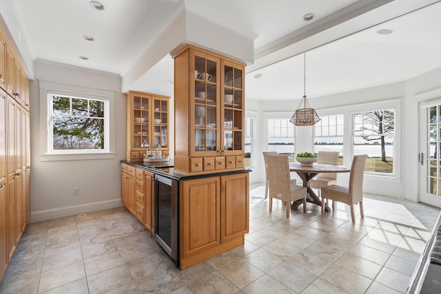 bar with wine cooler, baseboards, ornamental molding, and a healthy amount of sunlight