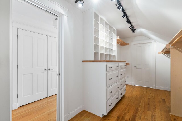walk in closet featuring vaulted ceiling and light wood finished floors