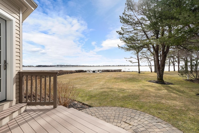 wooden deck featuring a lawn and a water view