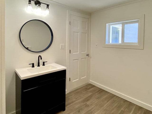 bathroom with vanity, hardwood / wood-style floors, and crown molding