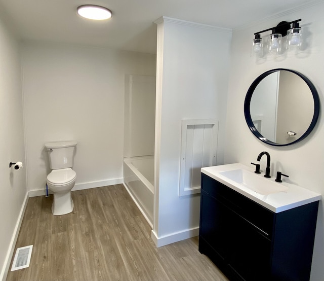 full bathroom with washtub / shower combination, vanity, toilet, and hardwood / wood-style floors