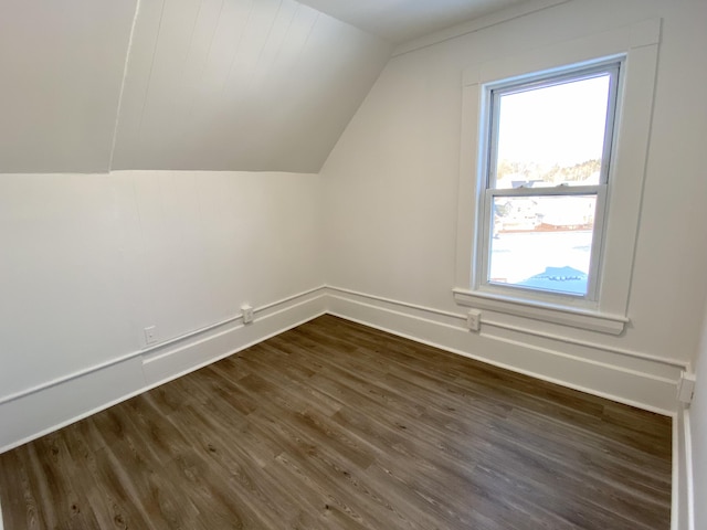 additional living space with dark wood-type flooring and vaulted ceiling