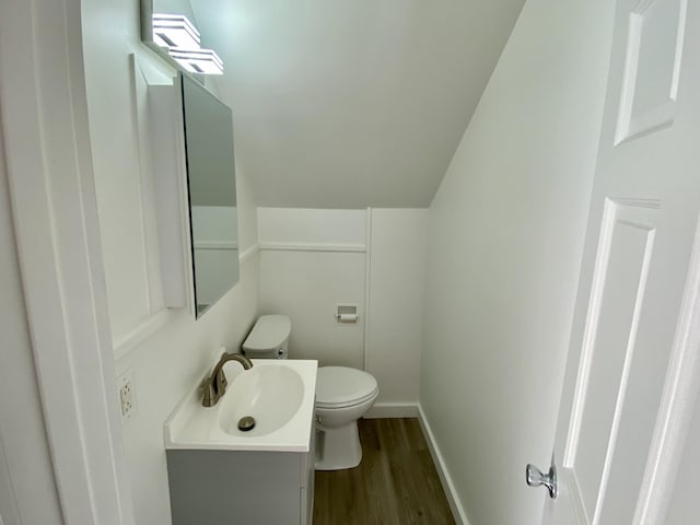 bathroom featuring vaulted ceiling, vanity, toilet, and hardwood / wood-style floors