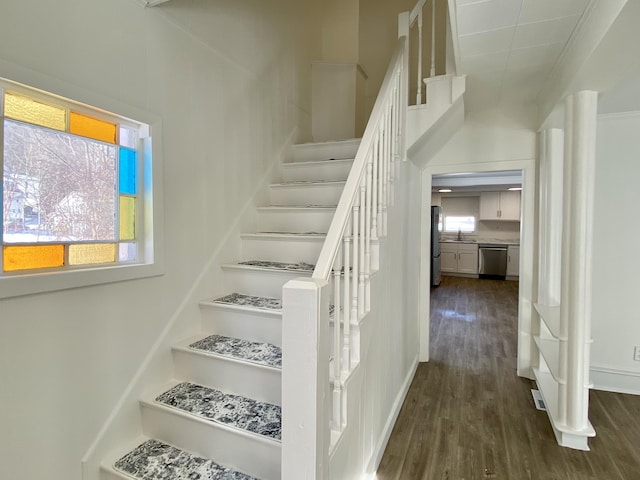 staircase featuring sink and wood-type flooring