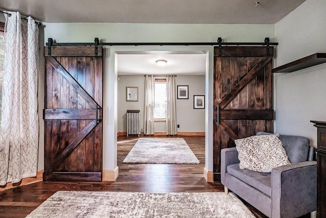 entrance foyer with a barn door, radiator heating unit, and dark hardwood / wood-style flooring