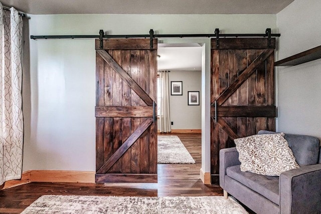 sitting room featuring hardwood / wood-style flooring and a barn door