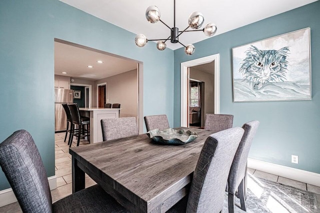 tiled dining room featuring a chandelier