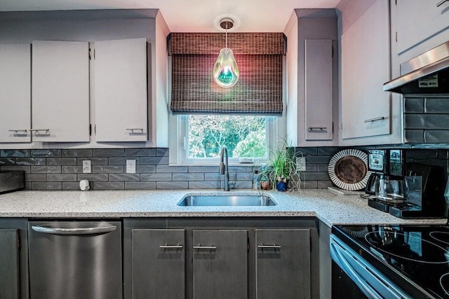 kitchen with decorative light fixtures, sink, exhaust hood, stainless steel dishwasher, and light stone countertops