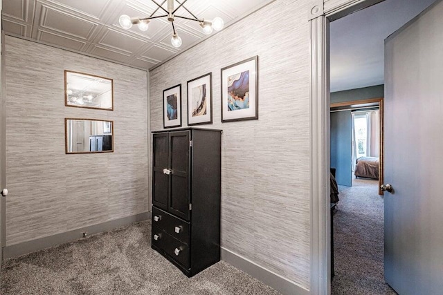 corridor featuring carpet floors and a notable chandelier