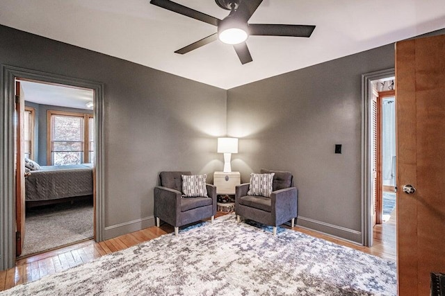 living area featuring light hardwood / wood-style flooring and ceiling fan