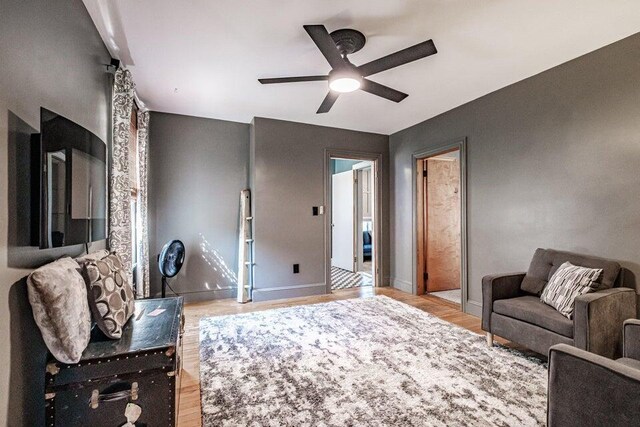 living room featuring ceiling fan and light hardwood / wood-style flooring