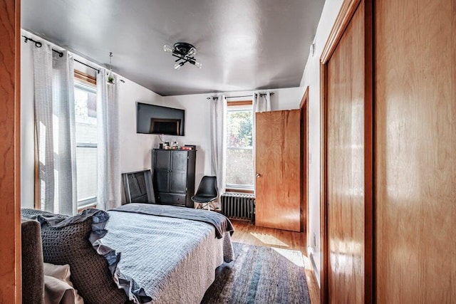 bedroom featuring radiator, a closet, and light wood-type flooring