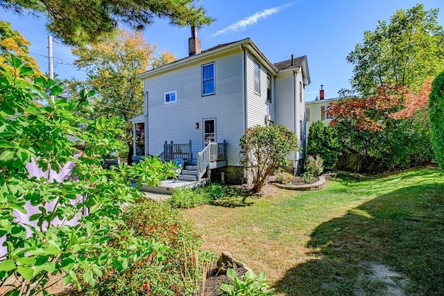 rear view of property featuring a wooden deck and a yard