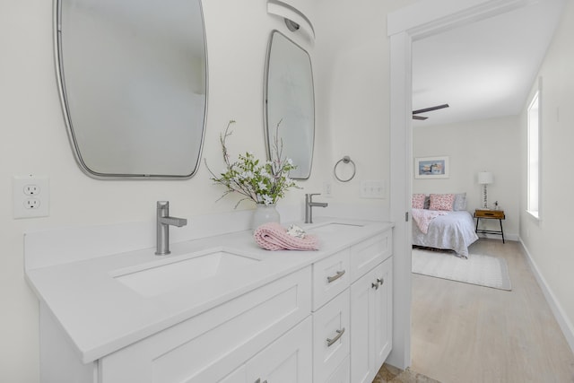 bathroom featuring ceiling fan, vanity, and wood-type flooring