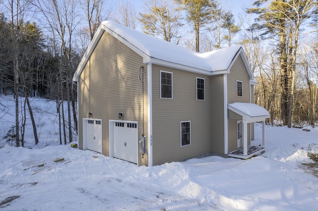 snow covered property featuring a garage