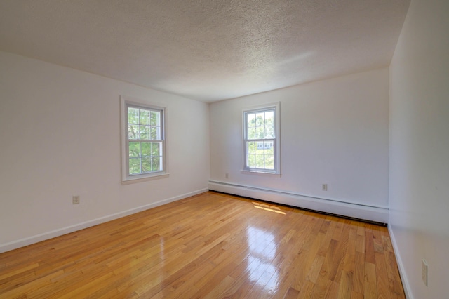 3 Sea Breeze Ave, Biddeford, ME 04005 - unfurnished room with a baseboard heating unit, light wood-style floors, and a textured ceiling
