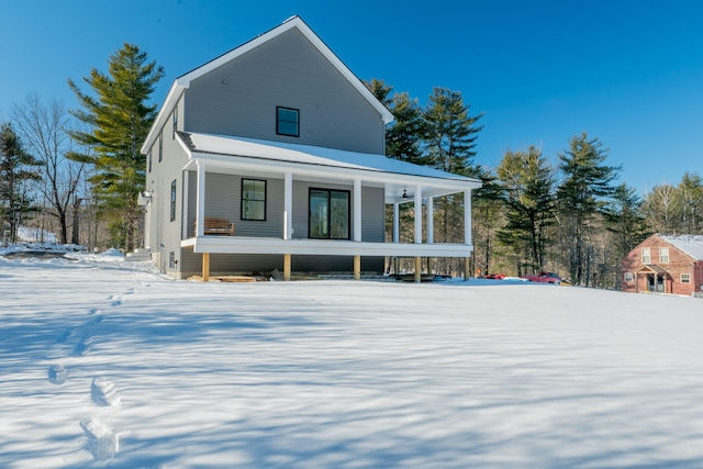 snow covered property featuring a porch