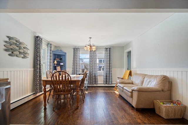 dining room featuring baseboard heating, dark hardwood / wood-style flooring, and a notable chandelier